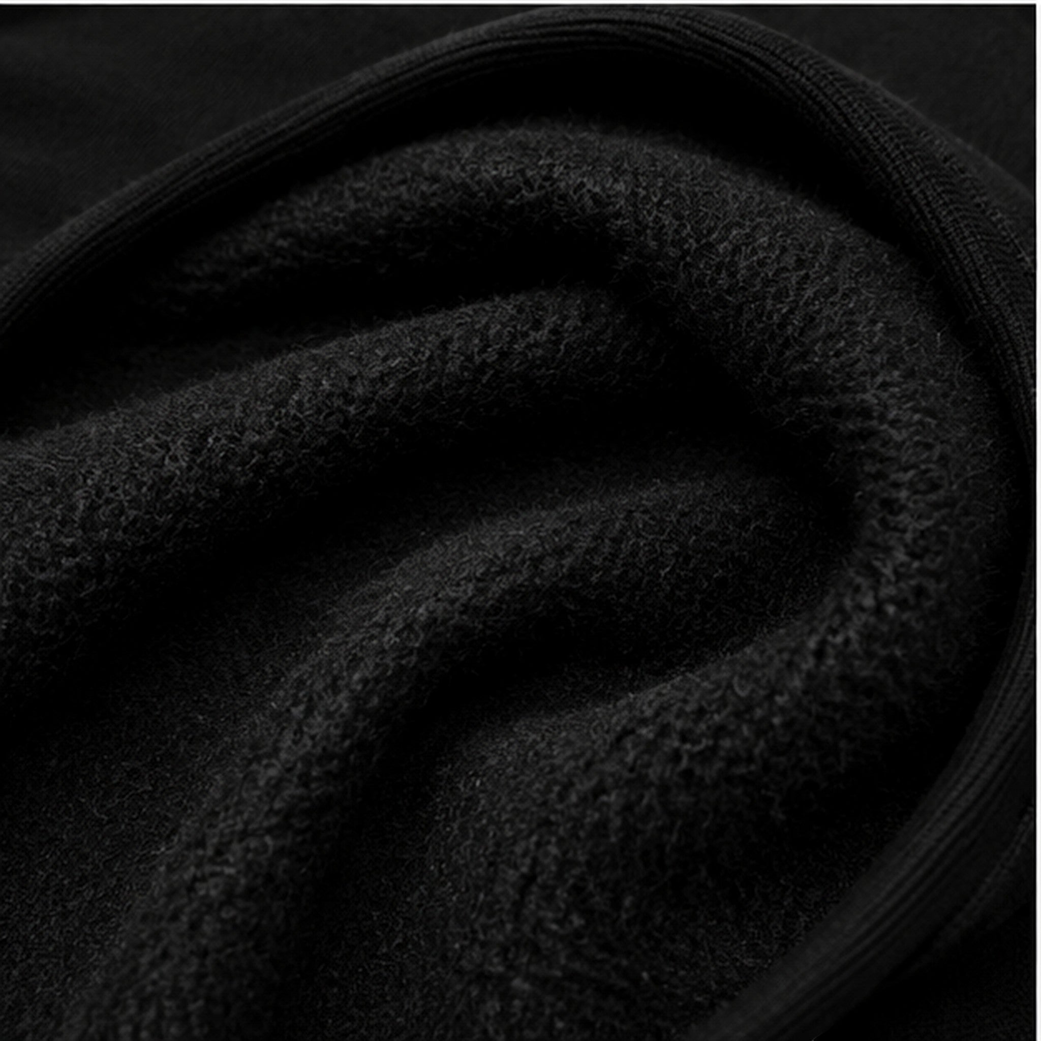 Close-up of the soft black fleece interior lining of a Vanta heavyweight hoodie, showing the thick fabric texture.