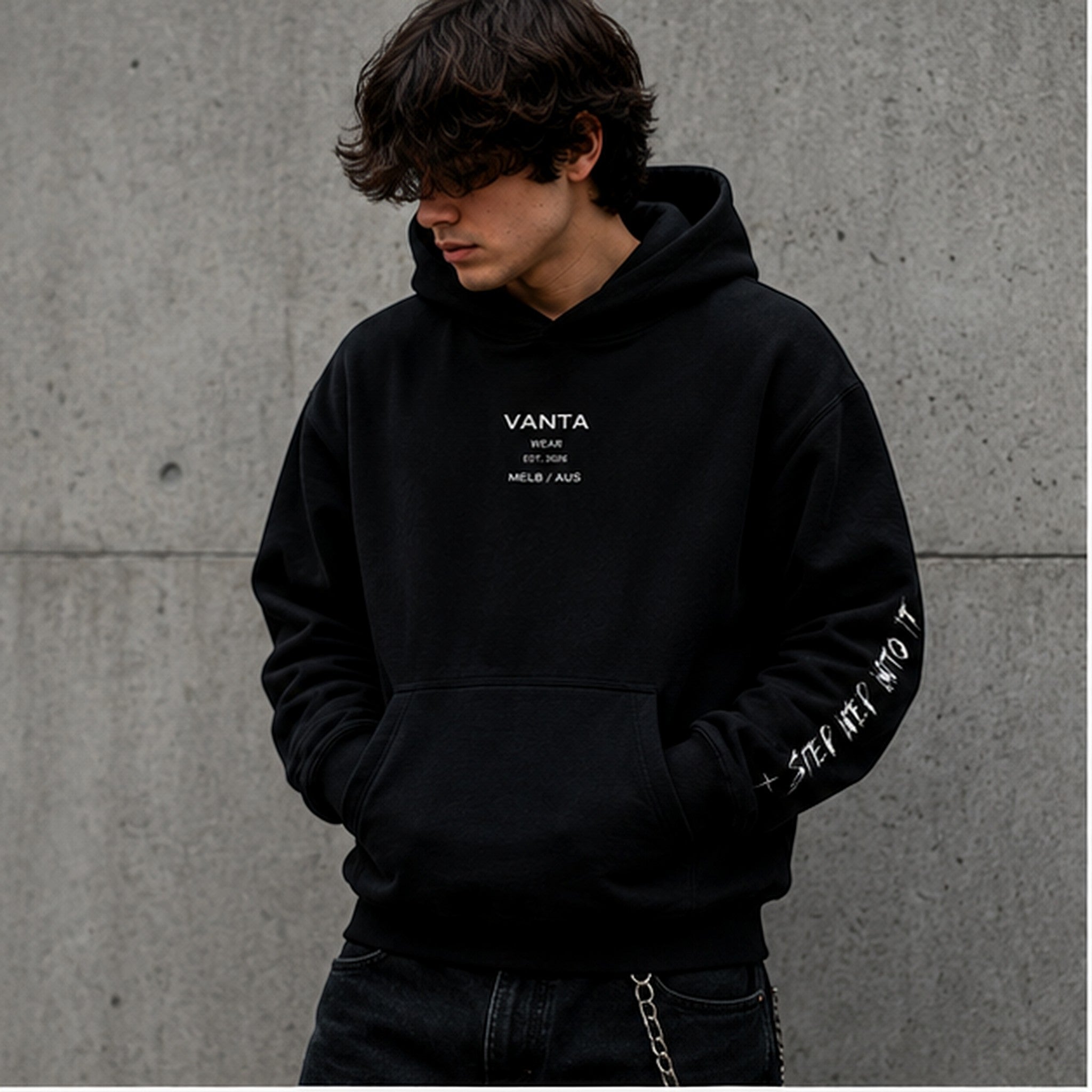 Vanta heavyweight black fleece hoodie with graffiti print on sleeve and chest logo, worn by a model in streetwear style