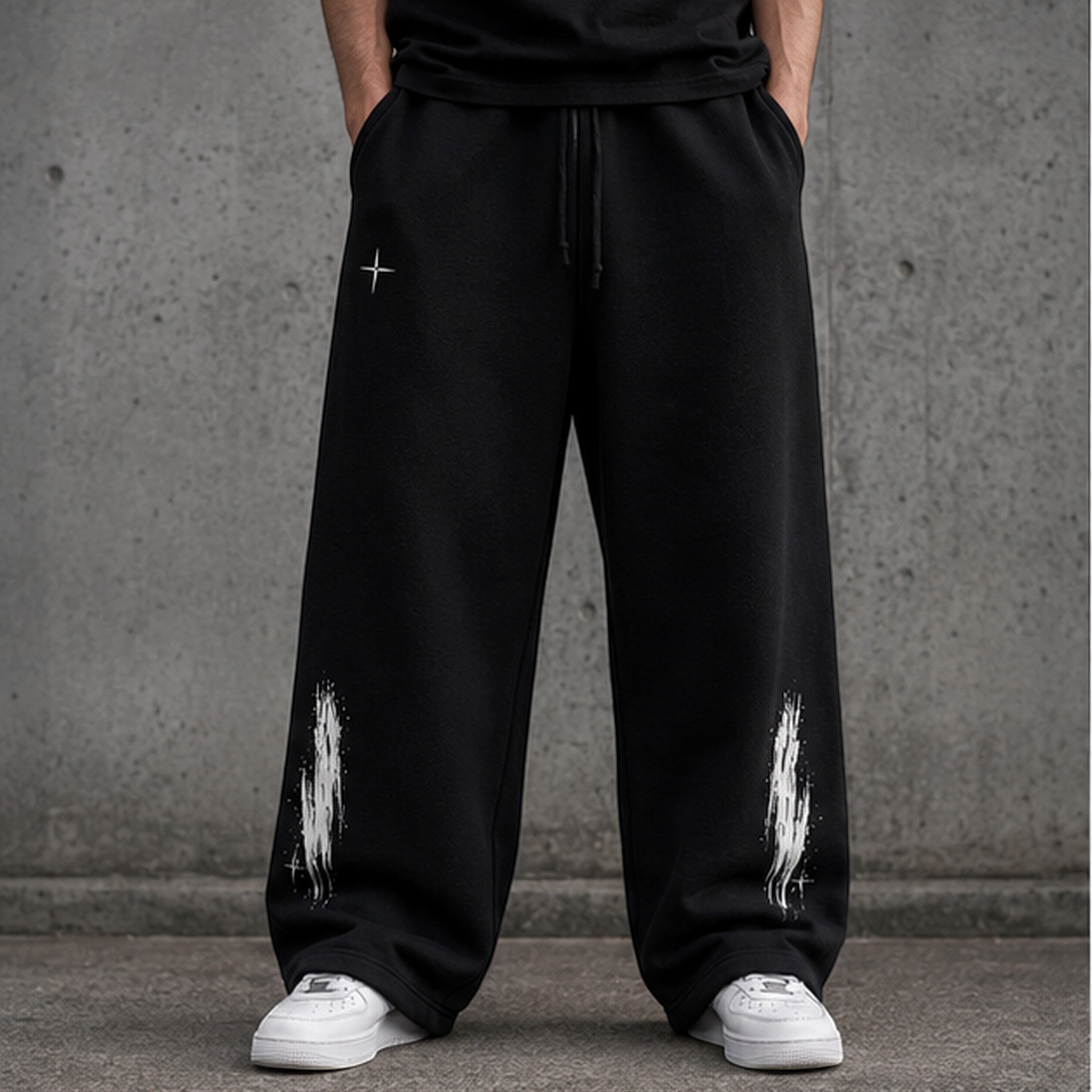 Vanta unisex black fleece sweatpants with an oversized fit, drawstring waist, and white graffiti-style leg prints.